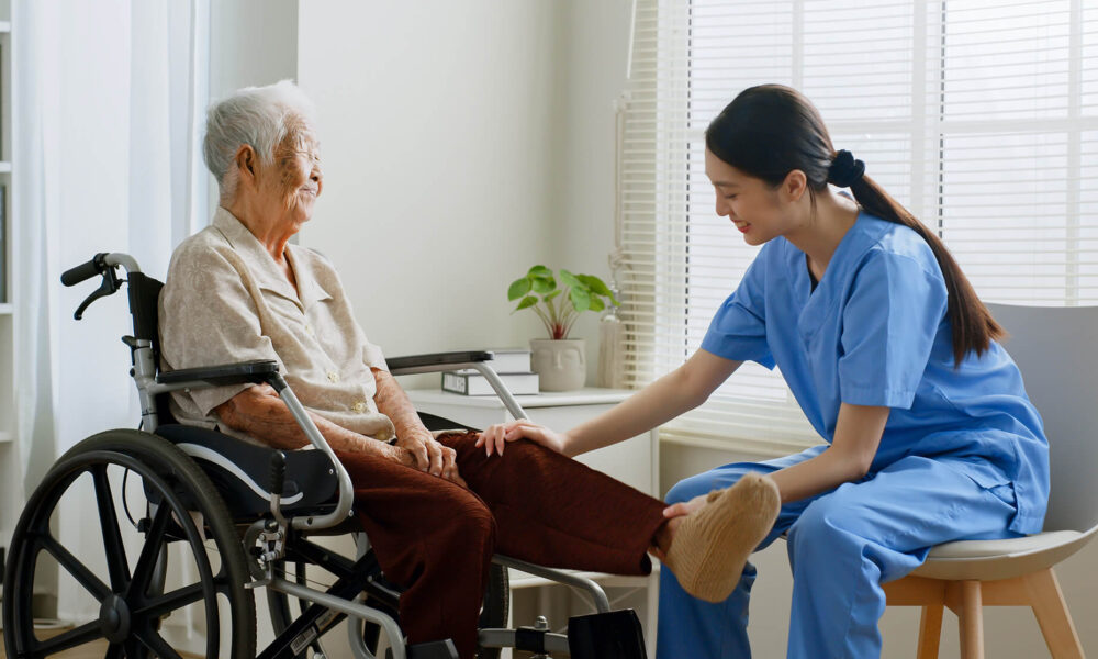 a NDIS registered physiotherapist providing assistance to an elderly woman on a wheelchair