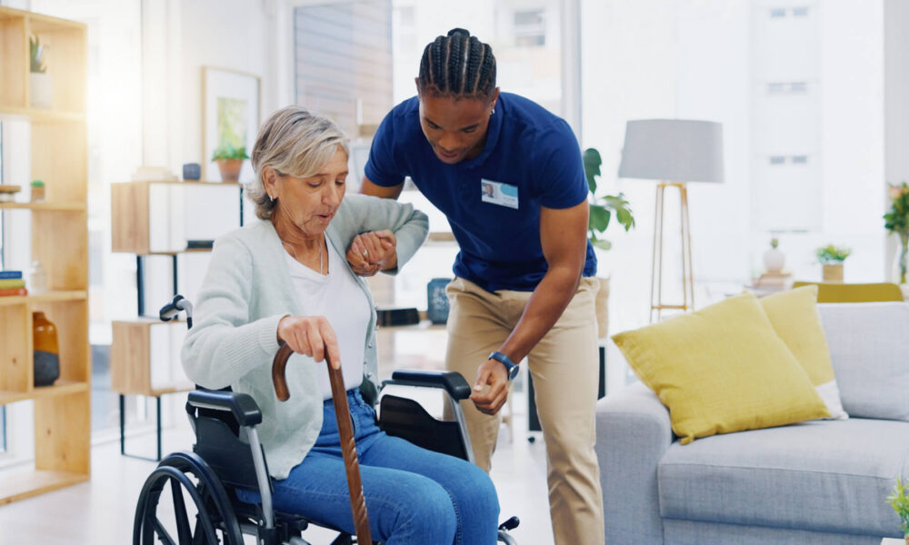 a male NDIS worker providing assistance to an elderly woman in a wheelchair